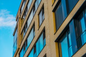 Modern orange brick commercial building with large blue double-glazed windows professional installation
